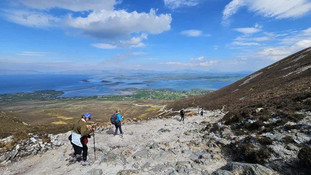 four guests hiking on Croagh Patrick with a view of clew bay