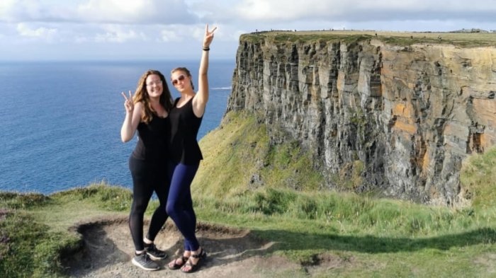 Two young female guests pose at the Cliffs of Moher
