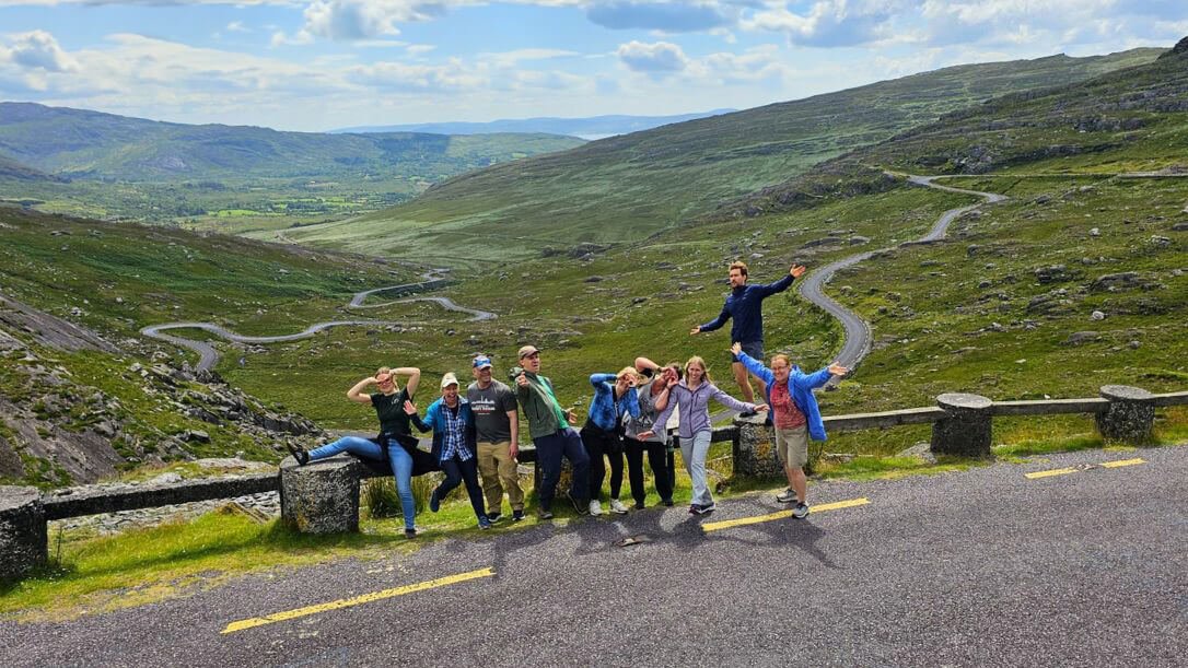 A group of guests posing with their hands in the air on the Healy Pass