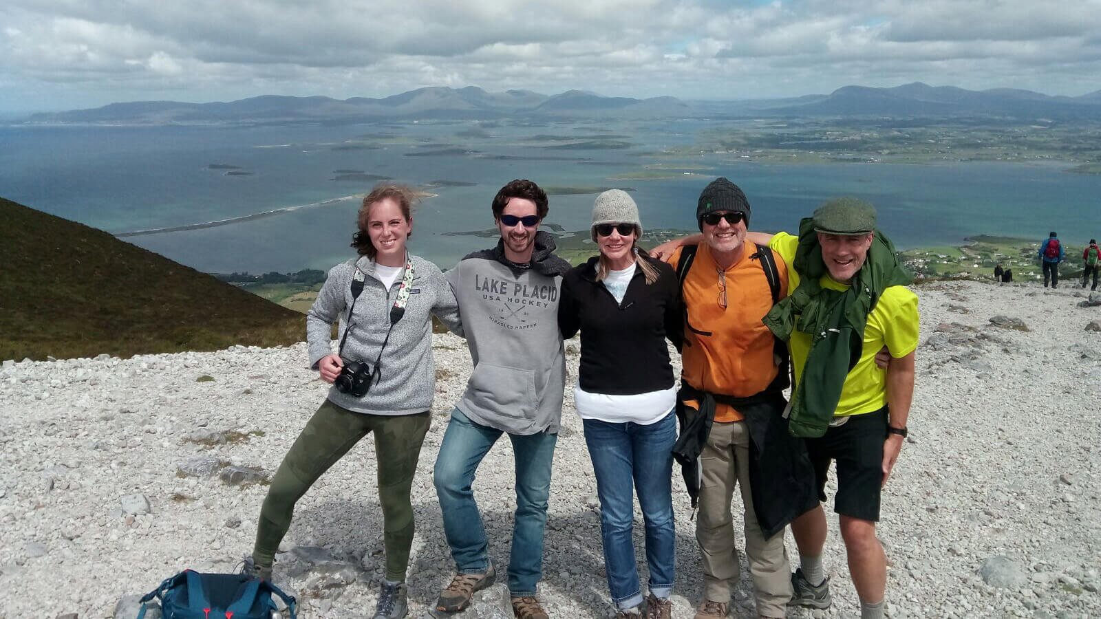 Vagabond group hiking Croagh Patrick in Ireland with a scenic view of Clew Bay in the background