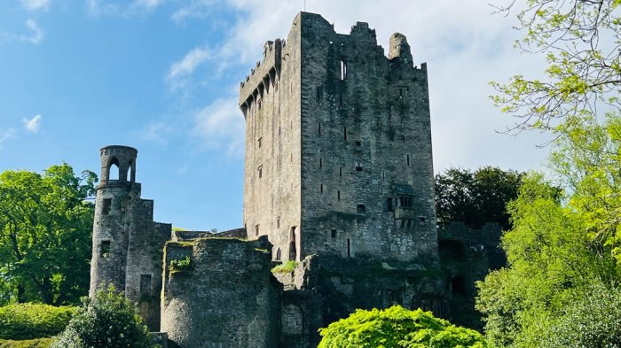 Blarney Castle tower with blue sky and green gardens in Ireland