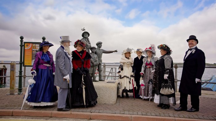 A group of actors dressed in old dresses and suits from the past on Cobh pier