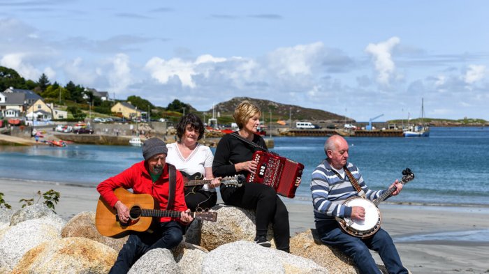 Three traditional Irish musicians playing on beach in Ireland