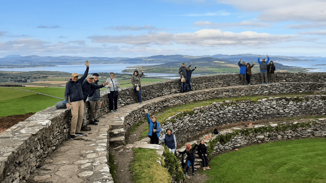 A group pf guests standing on grianan of aileach waving