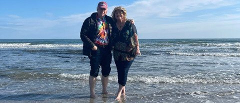 Two tour guests with their feet in the water in Northern Ireland