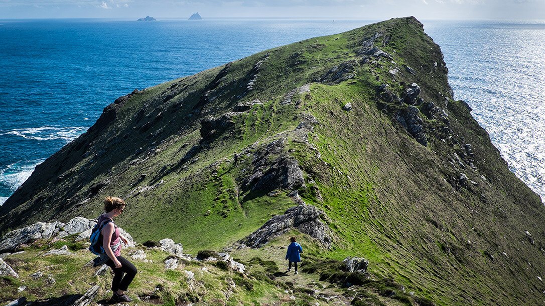 Two Vagabond guests hiking Bray Head on Valentia Island with the Skellig Islands in the background