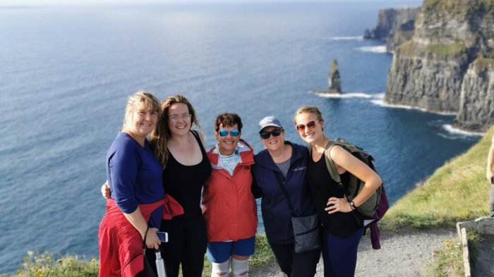 Five Vagabond guests posing with the Cliffs of Moher