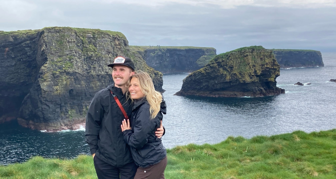 couple on a tour of ireland posing by scenic cliffs