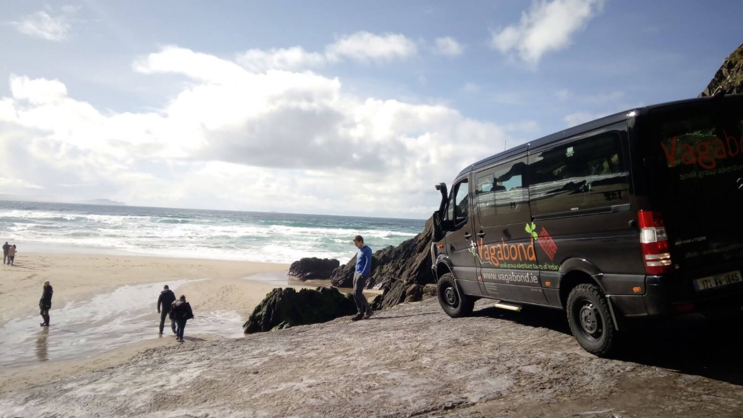 VagaTron tour vehicle parked up while Vagabond tour guests walk onto a scenic beach