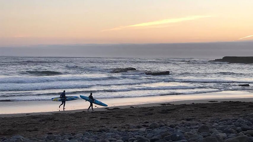 Surfers at sunset in Ireland