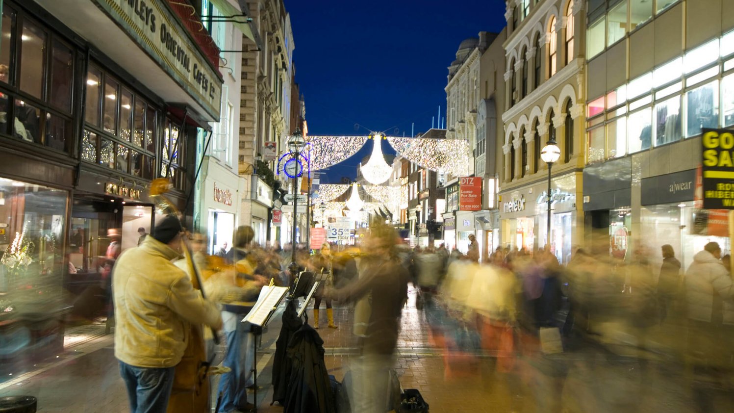 Hustle and bustle on Grafton Street at night including buskers