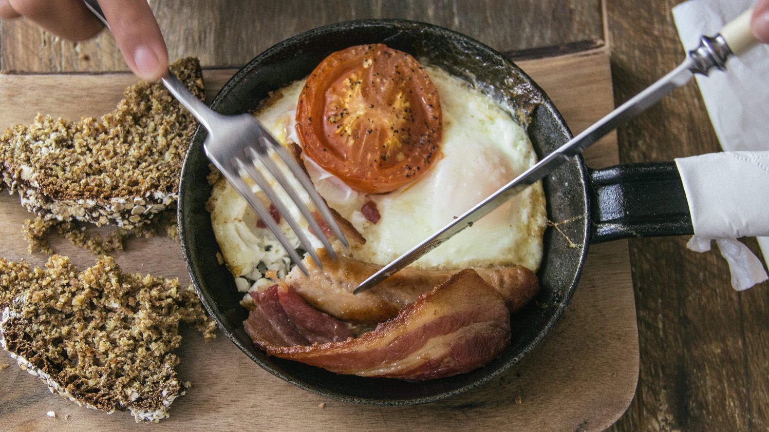 A cooked Irish breakfast served in a frying pan with soda bread